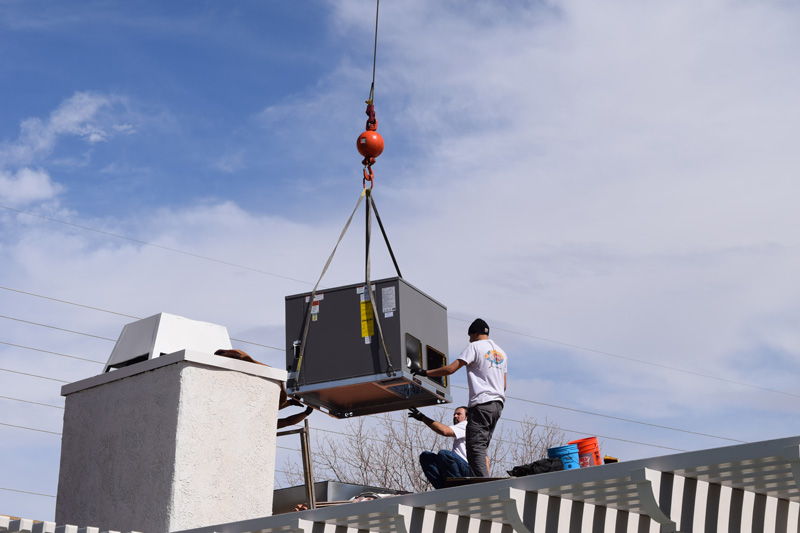 Rooftop AC replacement with Century Air technicians lifting new unit by crane in Las Vegas NV